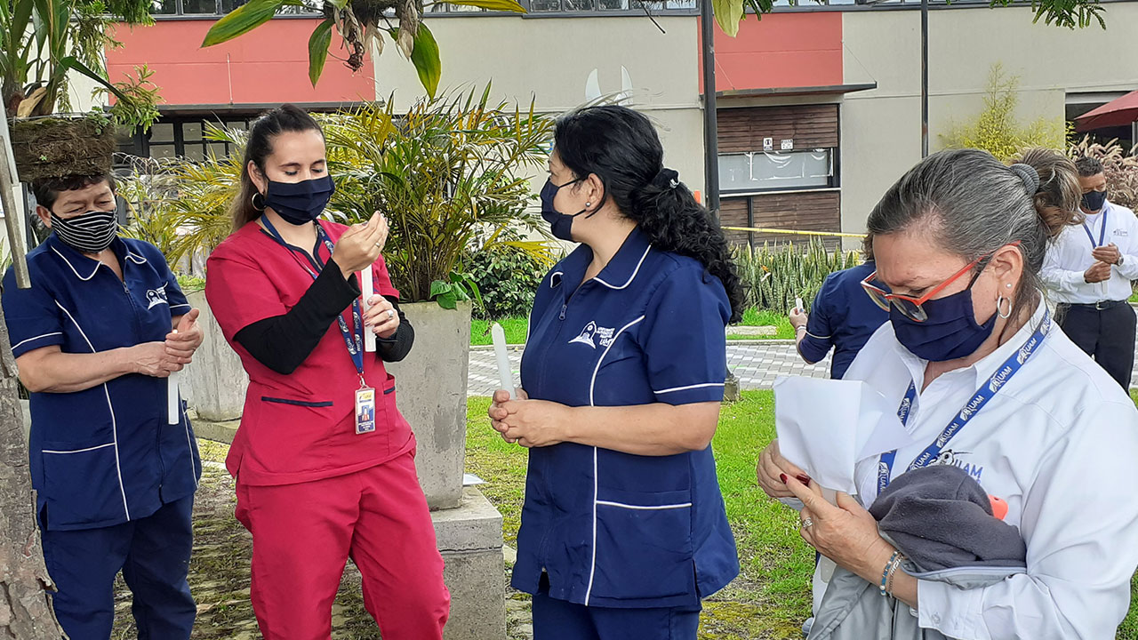 Persona sostiene una vela mientras se la entrega a alguien