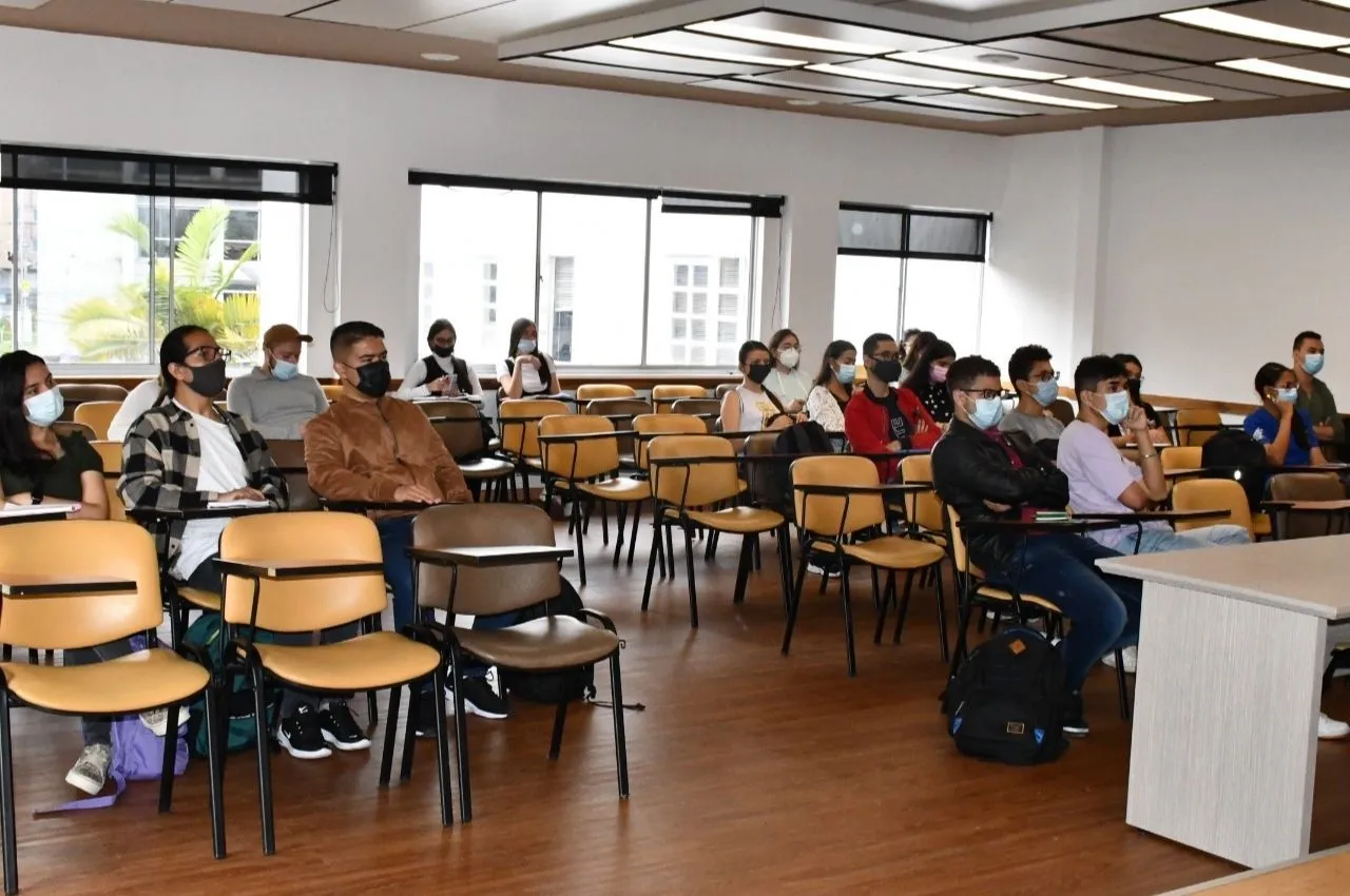 Personas en un salón escuchando las convocatorias Delfín