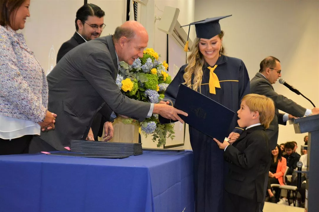 Graduada UAM es acompañada por su hijo en la entrega de diploma